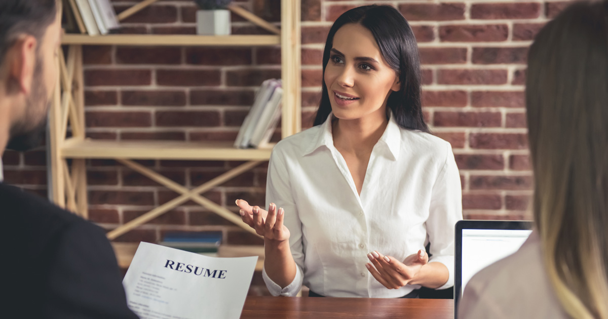 Beautiful female employee in suit is smiling during the job interview
