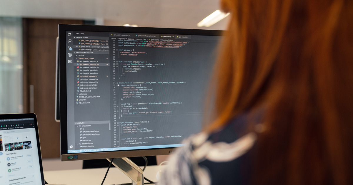 Female software engineer coding on computer