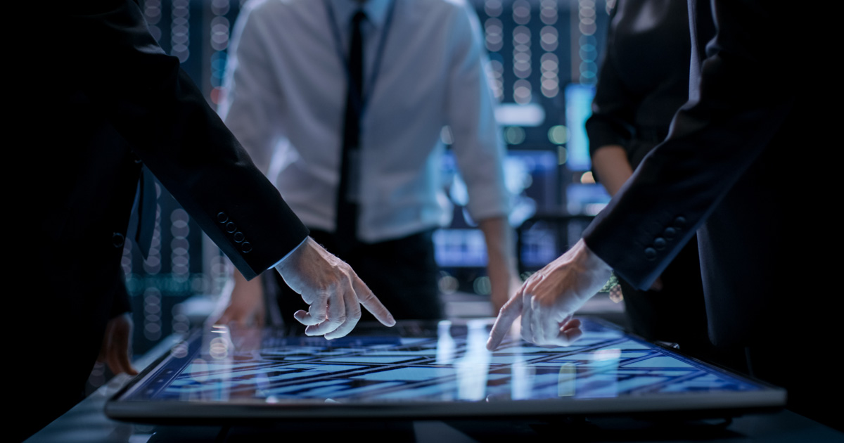 Corporate managers working at the table in monitoring room