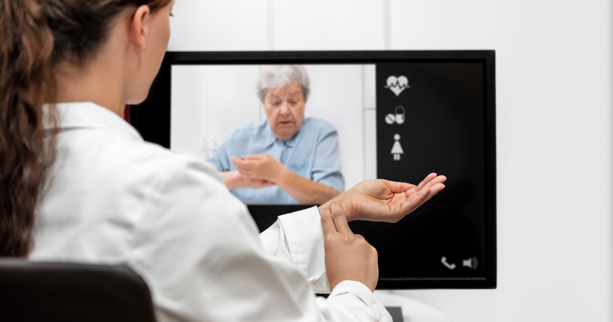 Doctor and senior woman taking the pulse together, telemedicine and videotelephony for medical health care