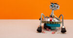Steampunk style professional robotic vacuum cleaner machine with hand brushes on orange wall background