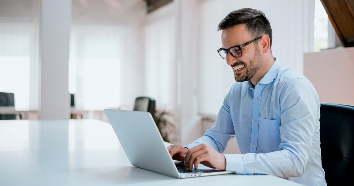 Portrait of young man sitting at his desk in the office
