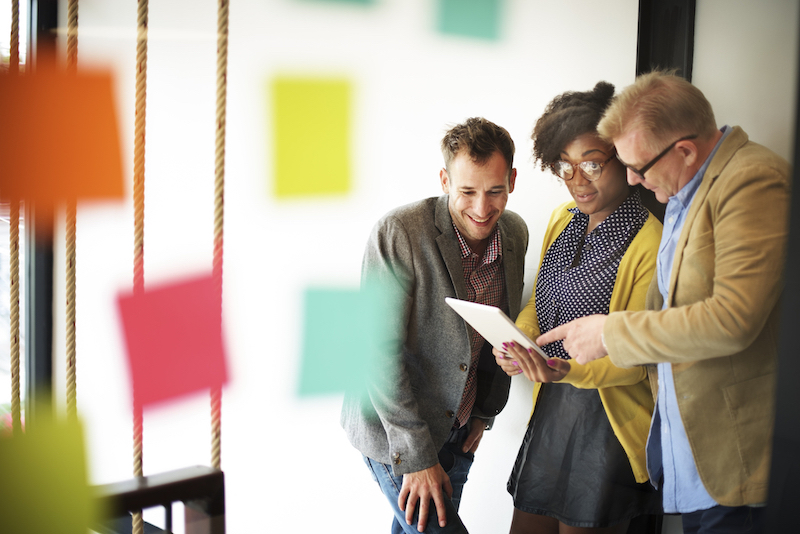 Three young professionals discuss their agile change management plan.