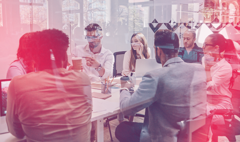 Group of young professionals sitting at a conference table during a meeting.