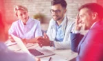 Two business consultants speak with a doctor about talent retention.