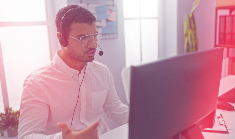 Call center service agent talking on phone while looking at QA call transcript