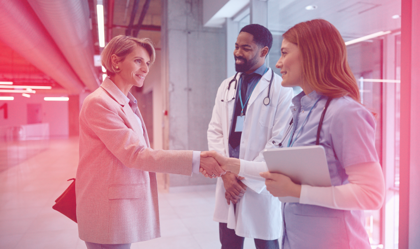 Smiling businesswoman meeting with medical experts to discuss a healthcare change management strategy for their hospital.