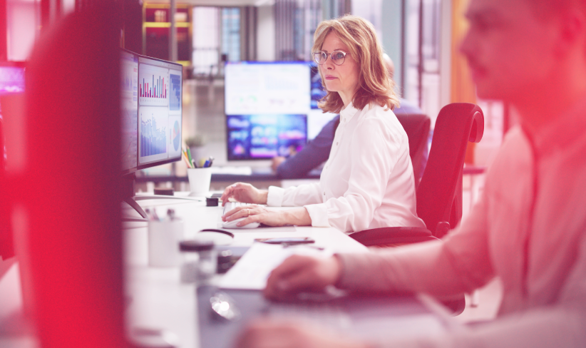 Woman and her coworker working on computers while leveraging big data and AI to make the most of their data