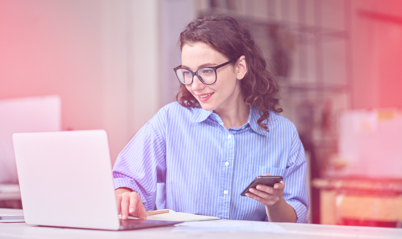 Woman working at a corporate office looking at her laptop
