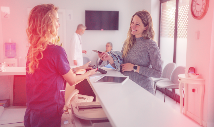 Woman at a hospital paying at the front desk for services received