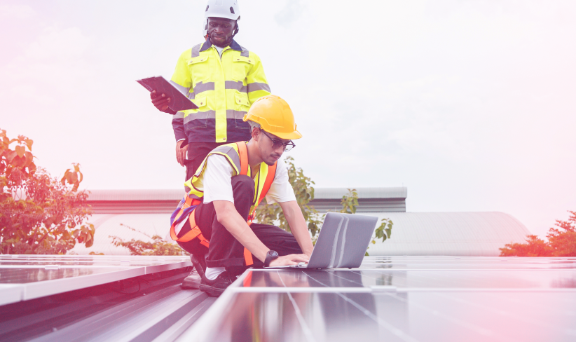 Two utilities professionals working on a clean energy project using a laptop to monitor performance