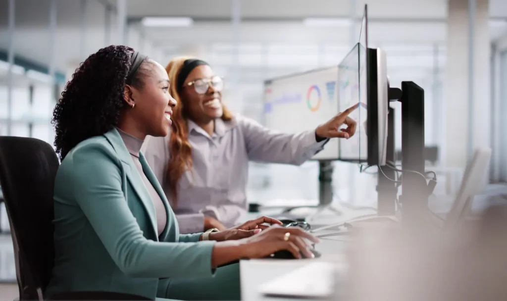 Two data analytics professionals looking at a computer screen