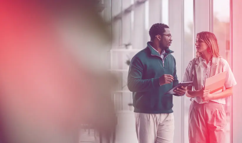 Two people walking and talking in an office